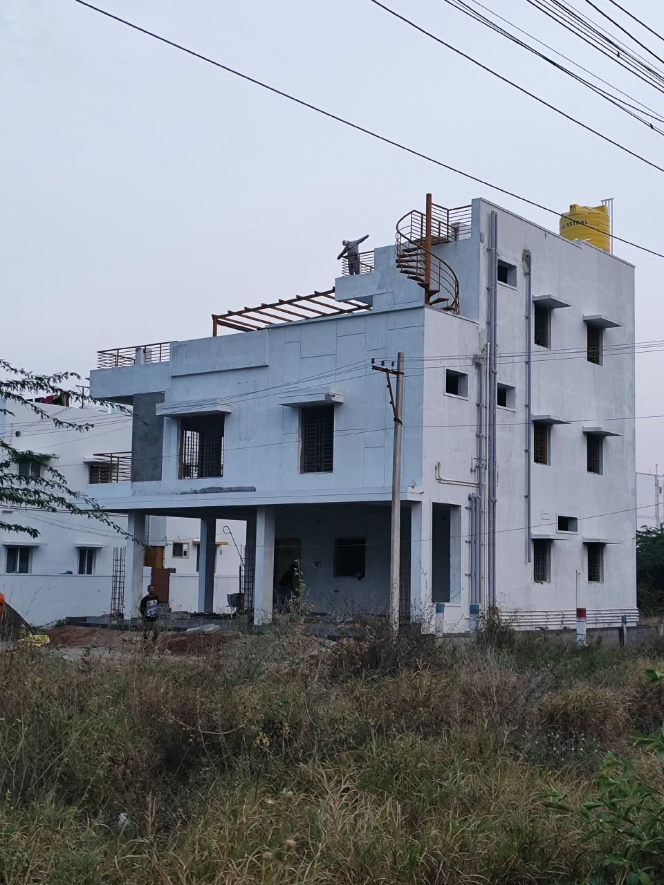 Completed multi-storey residence with spiral staircase and roof water tank