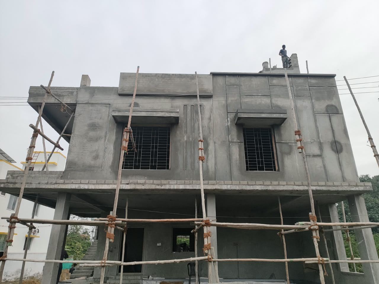 Residential building at plastering and elevation stage, window grills fitted